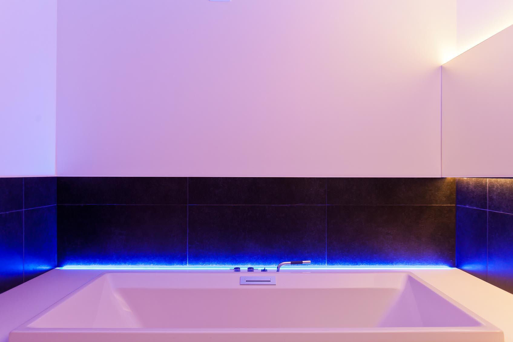 in deze design witte badkamer werd door maatwerk rgb ledstrip een speels kleur contrast toegevoegd