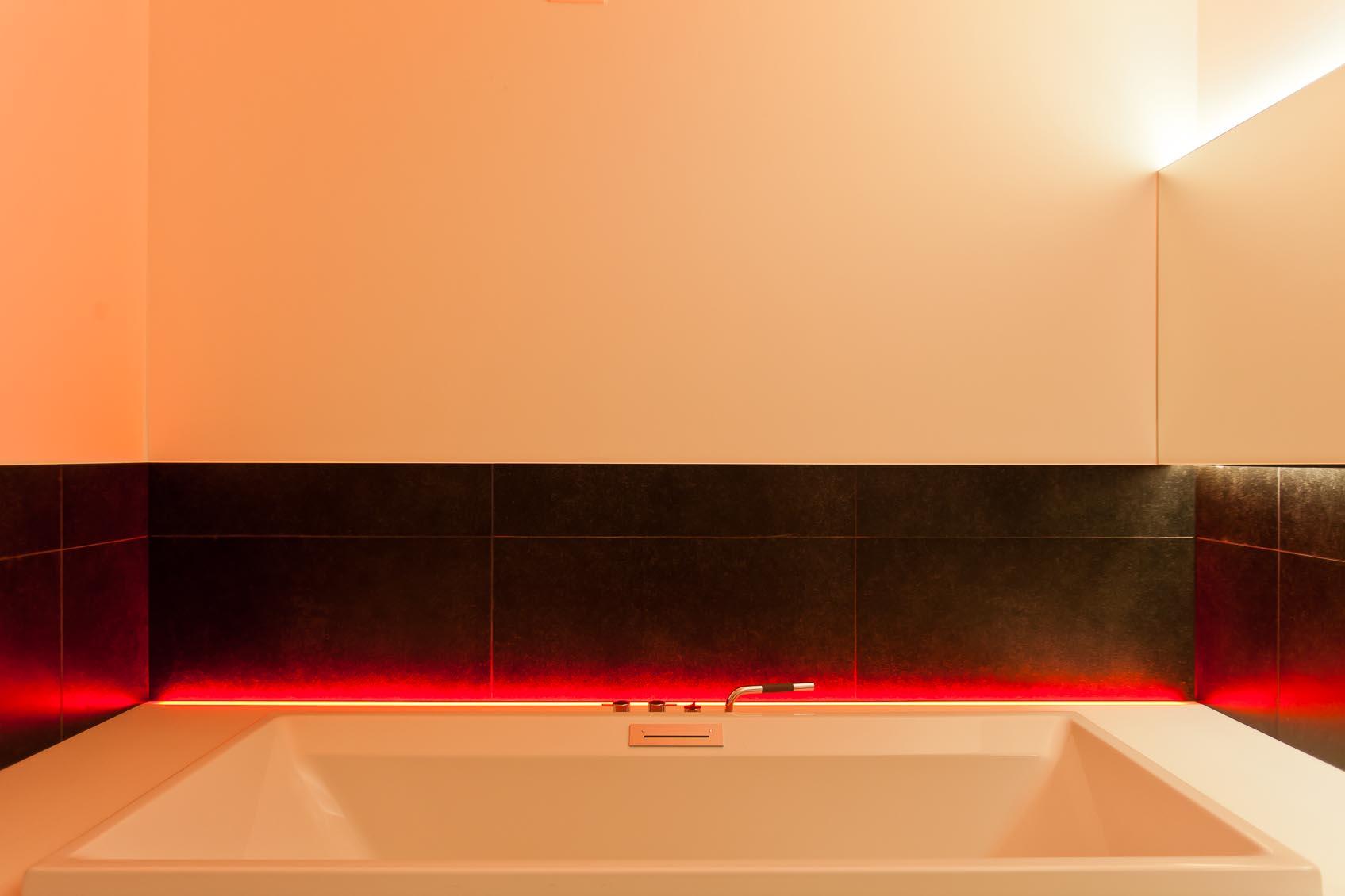 een speels kleur accent in strakke badkamer zorgt voor de juiste relaxerende sfeer